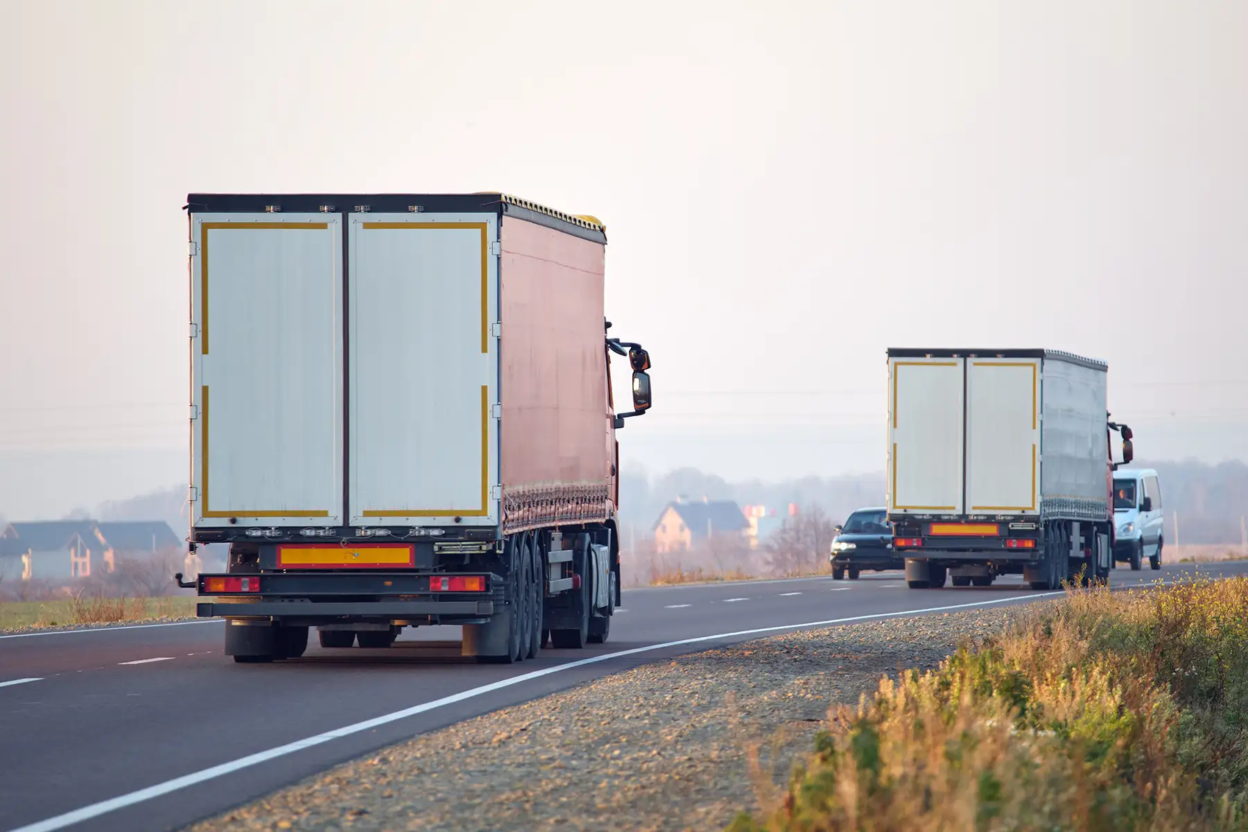 Delivery trucks moving along a roadway
